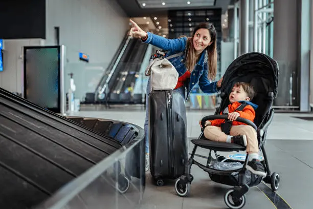 Mother traveling with a child in the Koopers Aero stroller at an airport, highlighting the stroller's travel-friendly features in Malaysia.