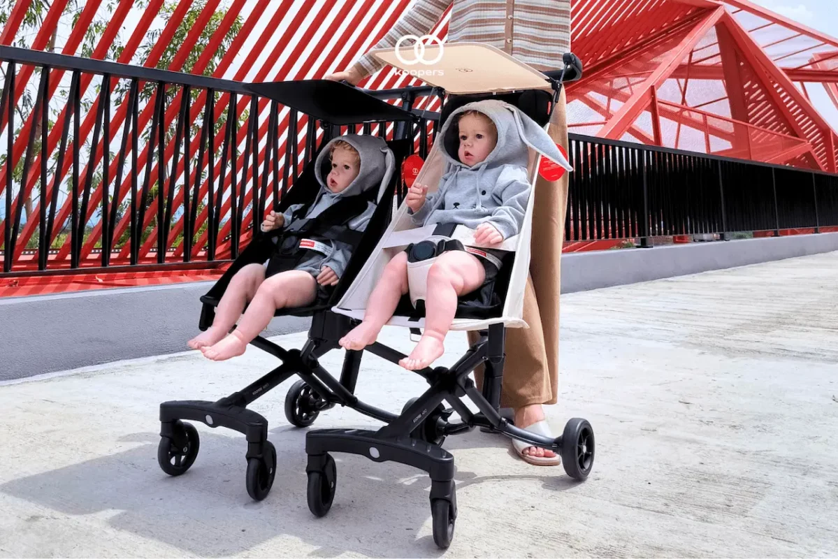 Two children seated comfortably in Koopers Aero travel strollers during an outdoor stroll, showcasing its hammock seat comfort feature.