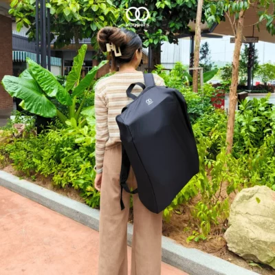 Woman carrying the Koopers Aero travel stroller in its backpack-style travel bag, perfect for lightweight and convenient portability in Malaysia.