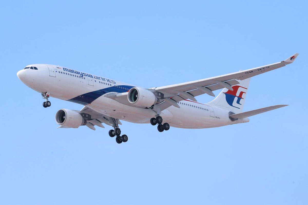 how-to-fly-with-a-car-seat-&-stroller-1 Malaysia Airlines airplane flying in the sky with landing gear extended.
