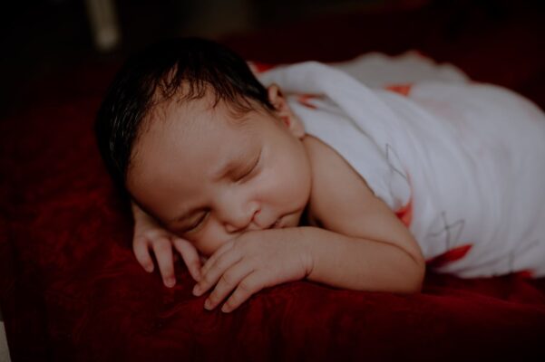 baby-cot-safety-checklist-what-malaysian-parents-should-never-overlook-2 Peacefully sleeping newborn wrapped in a swaddle, highlighting the importance of safe cot bedding practices for Malaysian parents