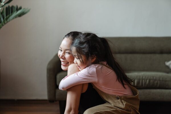 buying-baby-gear-online-vs-in-store-3 Malaysian daughter embracing her mum in a cozy living room setting, reflecting joyful parenting and home-based decision-making.