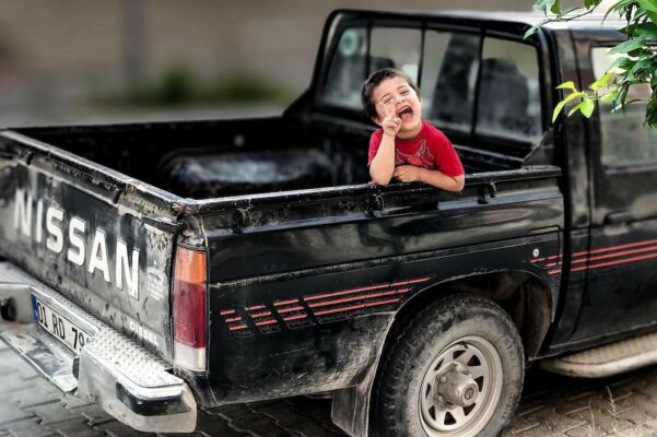 how-to-baby-proof-your-car-for-a-safe-car-6 Child dangerously riding in pickup truck bed — importance of baby car seats