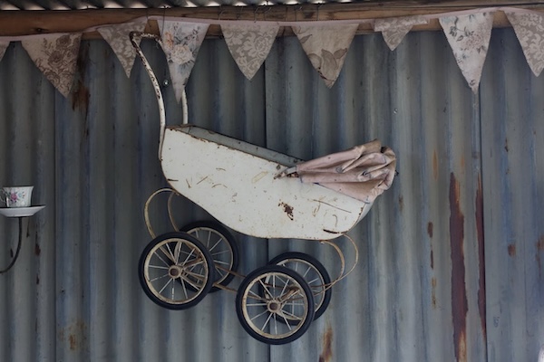 how-to-fold-store-maintain-koopers-stroller-6 Vintage baby stroller with large metal wheels and canopy, showing evolution of stroller design over time.