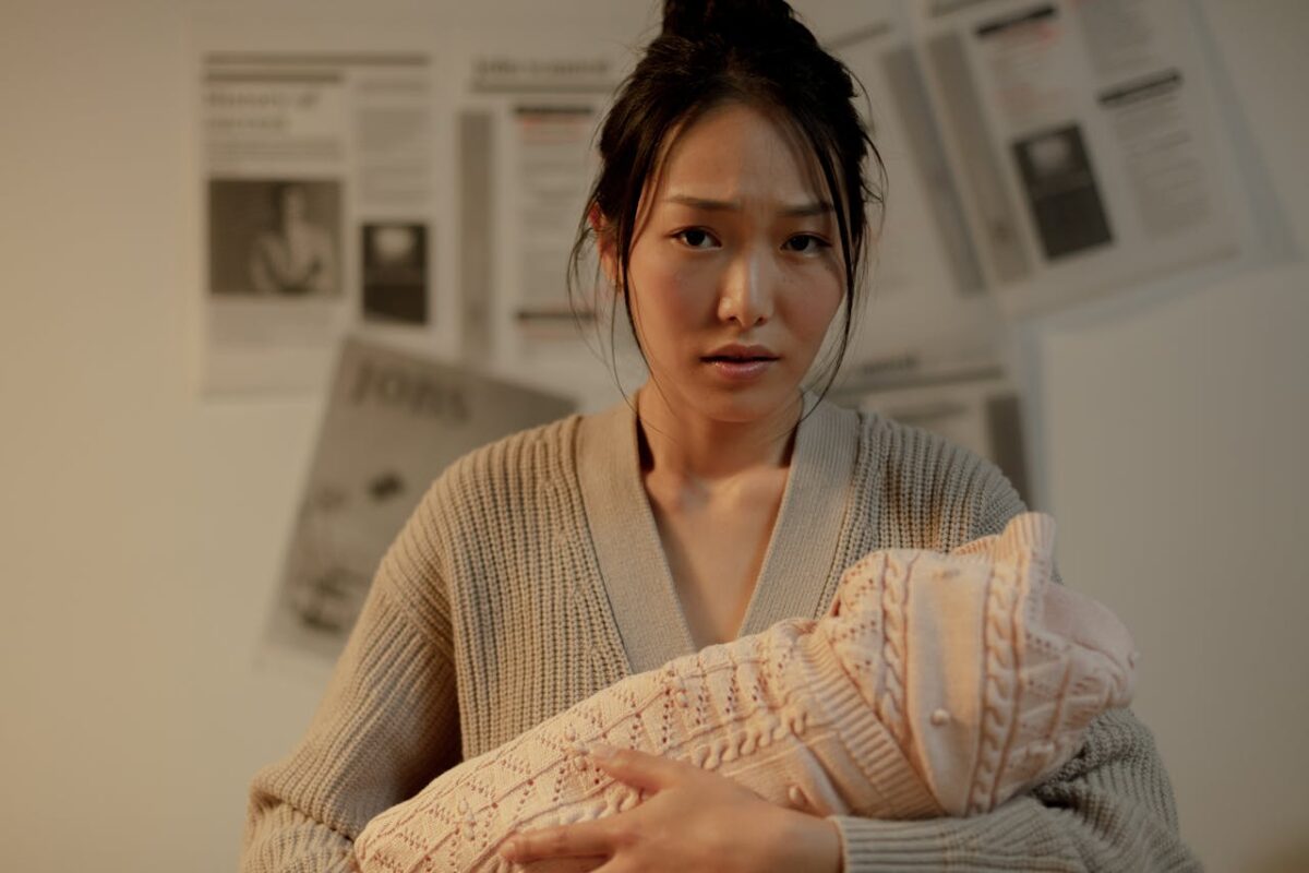 Concerned mother holding newborn — baby car seat safety awareness in Malaysia