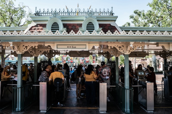how-to-use-baby-stroller-in-theme-parks-malls-public-transit-without-hassle-4 Crowds entering a theme park through security gates, illustrating stroller-friendly entry points and family outing preparations in Malaysia