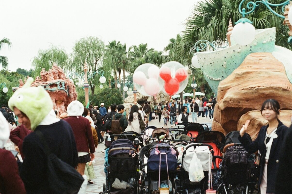 Dozens of strollers parked at a theme park with families and children nearby, highlighting stroller-friendly facilities for Malaysian parents on family outings