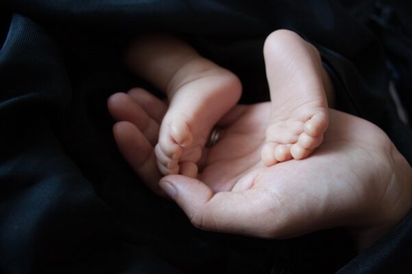 what-malaysian-parents-need-to-know-about-side-impact-protection-in-baby-car-seats-1 Newborn baby feet in parent's hand symbolizing child safety and protection