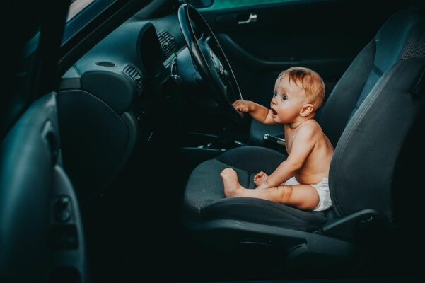 what-malaysian-parents-need-to-know-about-side-impact-protection-in-baby-car-seats-4 Unsecured baby sitting in car driver seat highlighting the importance of proper child car seats