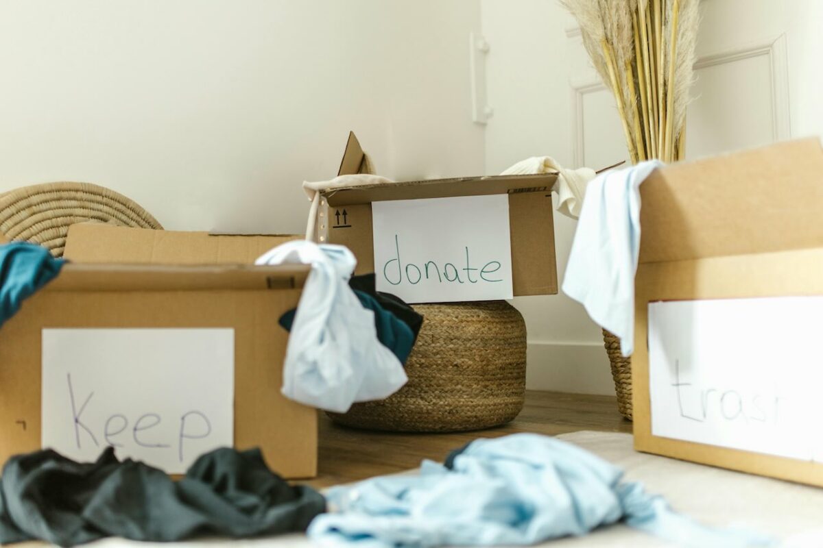 Cardboard boxes labeled “Keep,” “Donate,” and “Trash” for sorting old baby gear, promoting sustainable parenting in Malaysia.