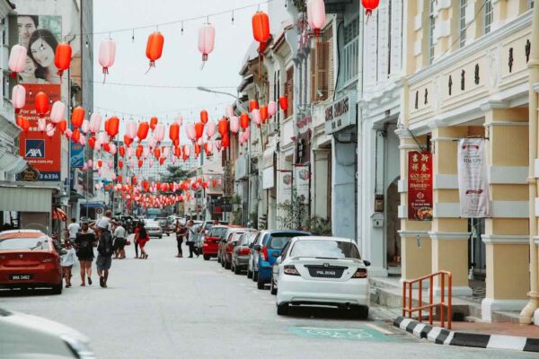 baby-stroller-cleaning-maintaining-1 Families strolling along a vibrant Malaysian street with red lanterns, highlighting the importance of keeping baby strollers clean in humid tropical climates.
