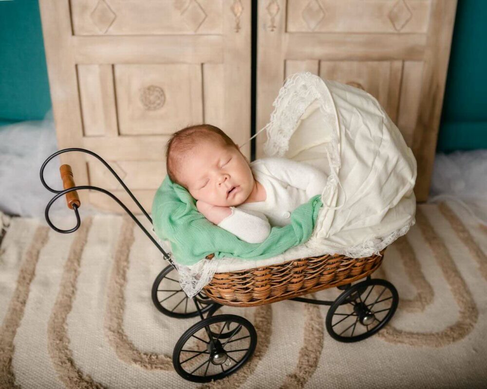 Sleeping baby in a classic stroller, illustrating the importance of a clean and hygienic stroller environment for newborn comfort.