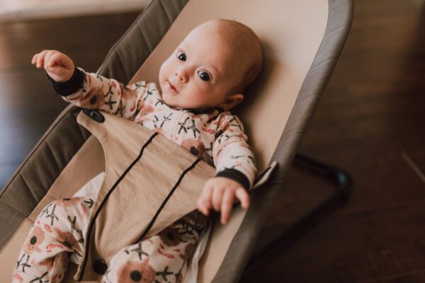 discover-best-baby-bouncer-swing-for-your-baby-in malaysia-1 Baby in festive outfit enjoying toy bar in baby bouncer during holidays, top choice for newborn soothing Malaysia