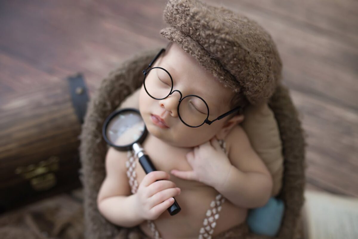 discover-best-baby-bouncer-swing-for-your-baby-in malaysia-2 Adorable baby boy in detective hat and glasses posing cutely, highlighting safe play in baby bouncer or rocker setups