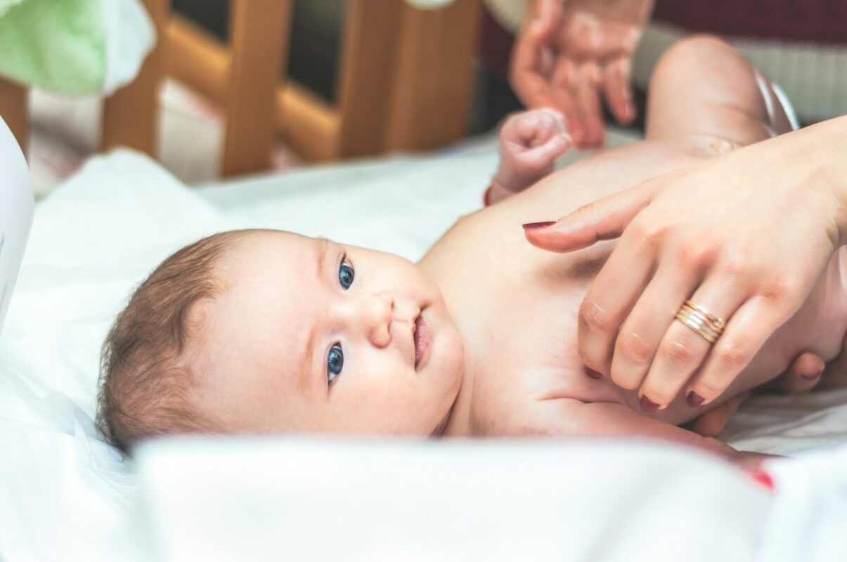 parents-guide-how-to-design-and-set-up-a-baby-nursery-7 Newborn baby being gently soothed during a calm care routine, highlighting comfort and bonding in a nursery setting.